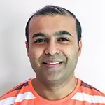 Sushant V., Chief Technology Officer, smiling in a striped orange and navy shirt against a light background.